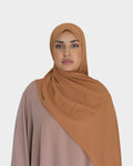 HIJABI LONDON tan chiffon hijab draped elegantly over a model wearing a beige abaya. Lightweight and breathable fabric.